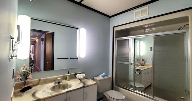 full bathroom featuring vanity, combined bath / shower with glass door, ornamental molding, and toilet