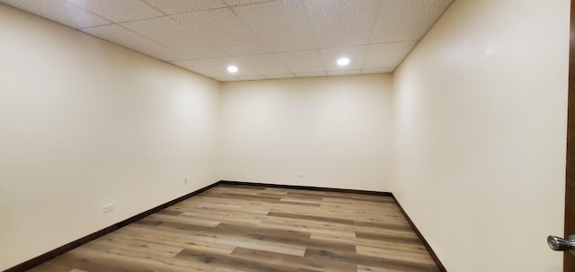 unfurnished room featuring a drop ceiling and light wood-type flooring