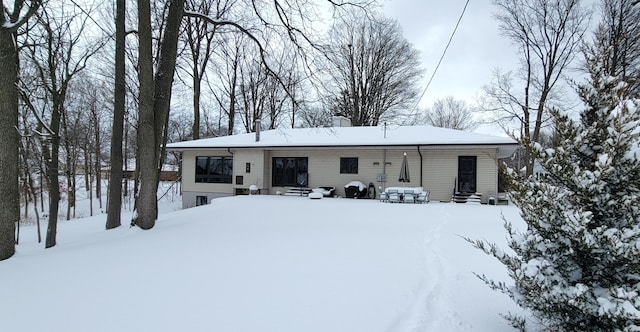 view of snow covered back of property