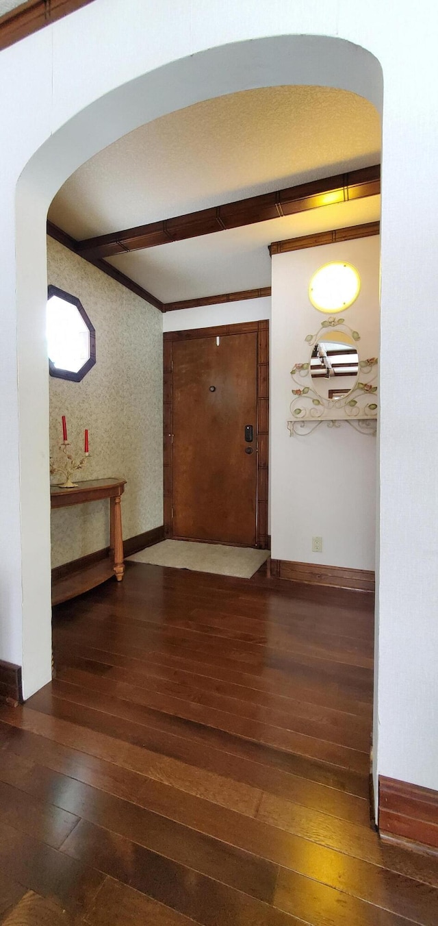 corridor with beamed ceiling and dark hardwood / wood-style floors