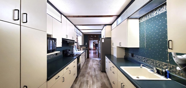 kitchen with a sink, white cabinetry, black appliances, and dark countertops