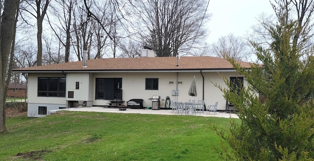 rear view of property with a patio, a chimney, entry steps, a yard, and a shingled roof