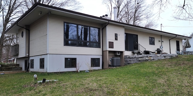 back of house featuring central AC, entry steps, and a lawn