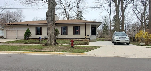 ranch-style home featuring a chimney, an attached garage, and concrete driveway
