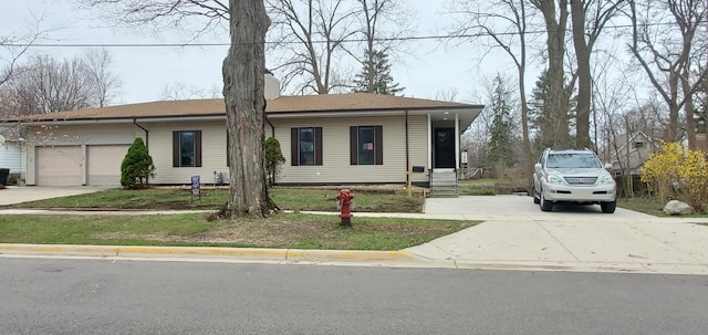 ranch-style house with an attached garage, a chimney, and driveway