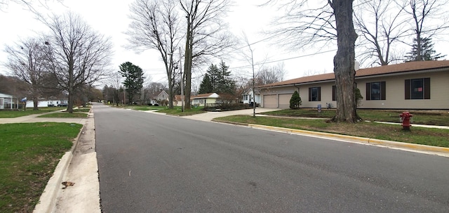 view of road featuring sidewalks, a residential view, and curbs