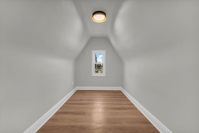 additional living space with hardwood / wood-style flooring and vaulted ceiling