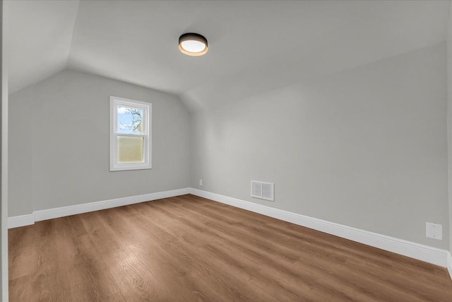 bonus room with hardwood / wood-style flooring and lofted ceiling