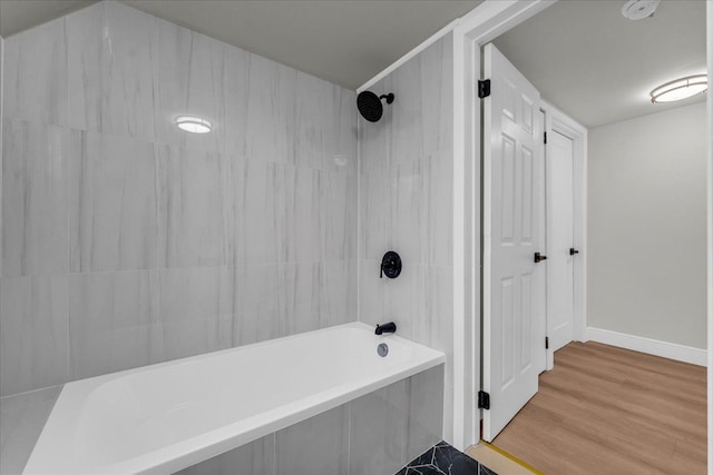 bathroom featuring hardwood / wood-style flooring and tiled shower / bath