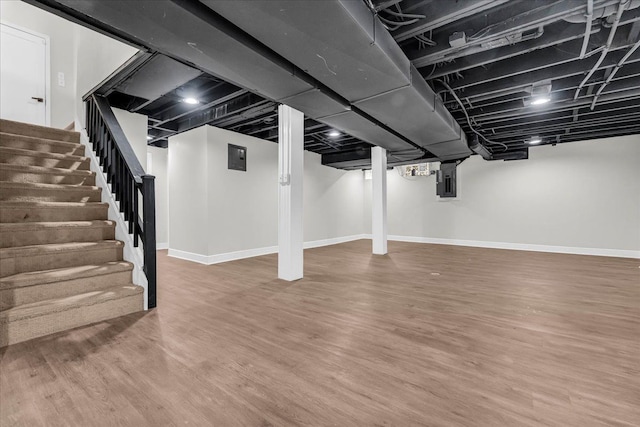 basement with hardwood / wood-style floors and electric panel