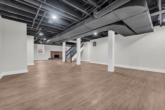 basement with wood-type flooring and a fireplace