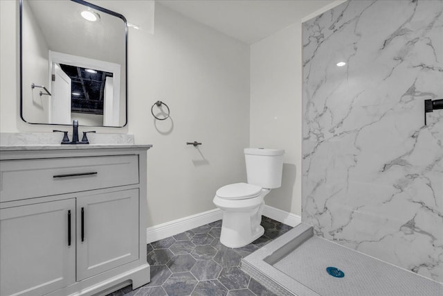 bathroom with vanity, toilet, and a shower