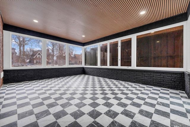 home theater room featuring wood ceiling, brick wall, and plenty of natural light