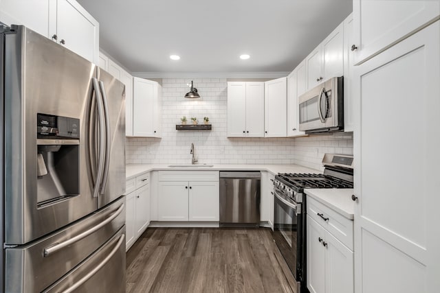 kitchen with sink, tasteful backsplash, dark hardwood / wood-style flooring, stainless steel appliances, and white cabinets