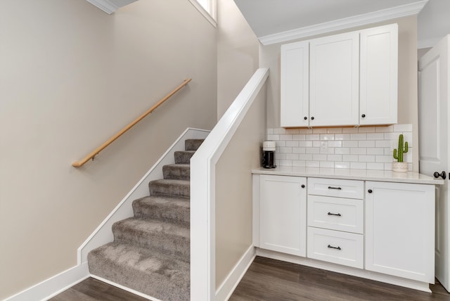 staircase featuring wood-type flooring and ornamental molding