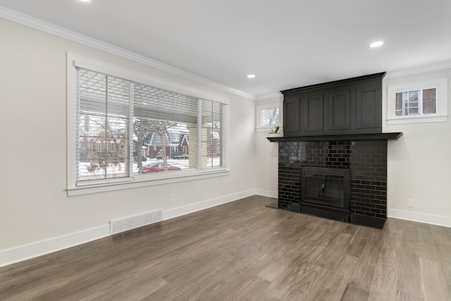 unfurnished living room featuring a fireplace, wood-type flooring, and ornamental molding