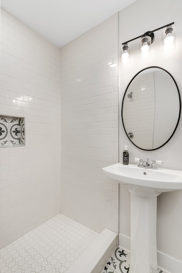 bathroom with tiled shower and tile patterned flooring