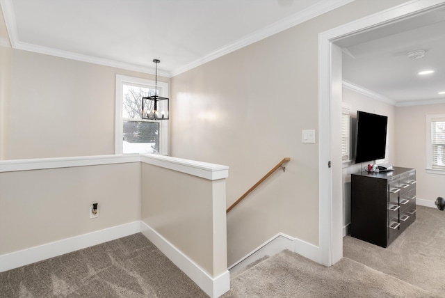 staircase featuring a notable chandelier, ornamental molding, carpet floors, and a wealth of natural light