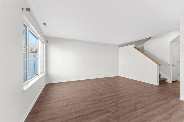 unfurnished living room with dark wood-type flooring