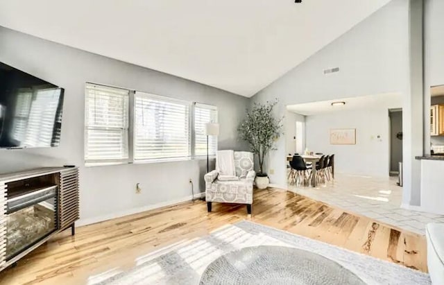 living area featuring vaulted ceiling and hardwood / wood-style floors