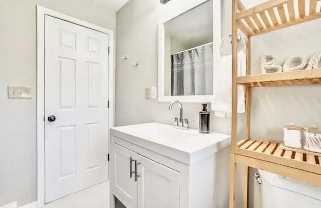 bathroom with vanity, curtained shower, and toilet