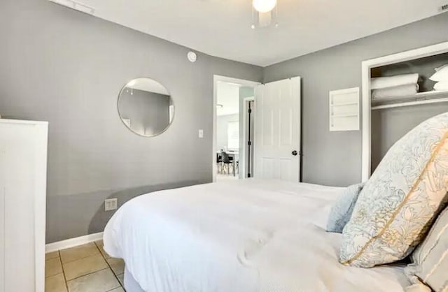 bedroom with light tile patterned flooring, ceiling fan, and a closet