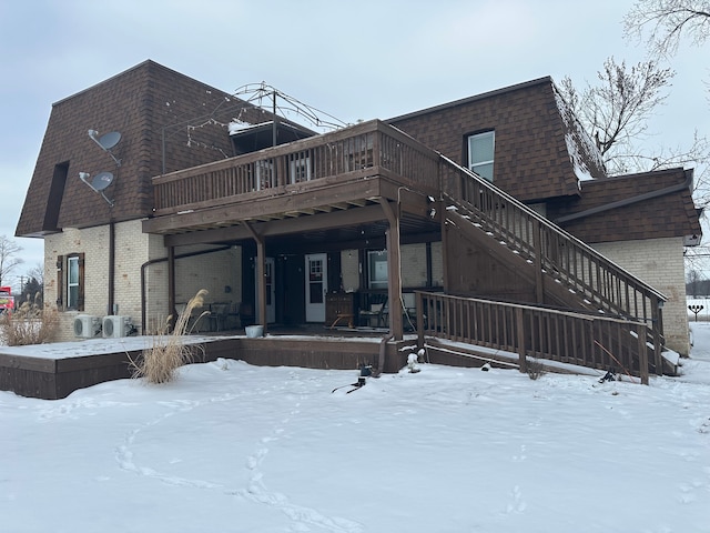 snow covered property with a wooden deck