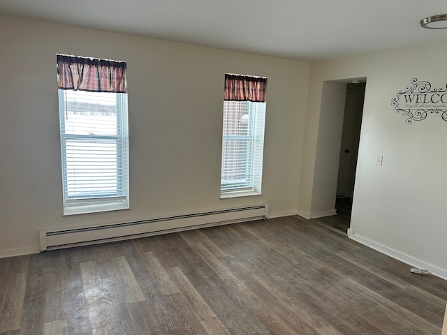 spare room with a baseboard radiator and dark hardwood / wood-style flooring