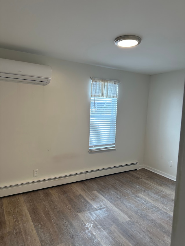 empty room featuring a baseboard radiator, a wall mounted air conditioner, and light hardwood / wood-style floors