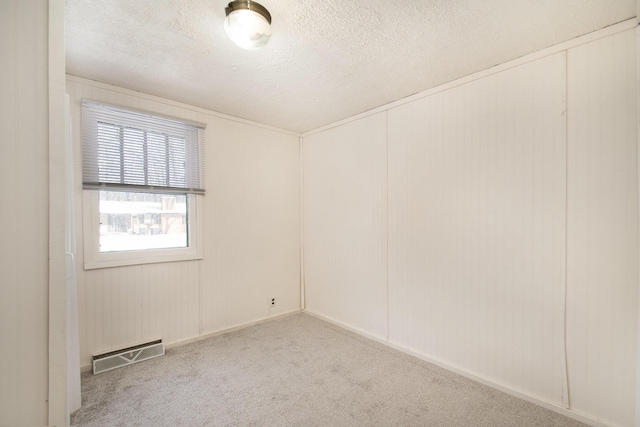 carpeted empty room with a textured ceiling