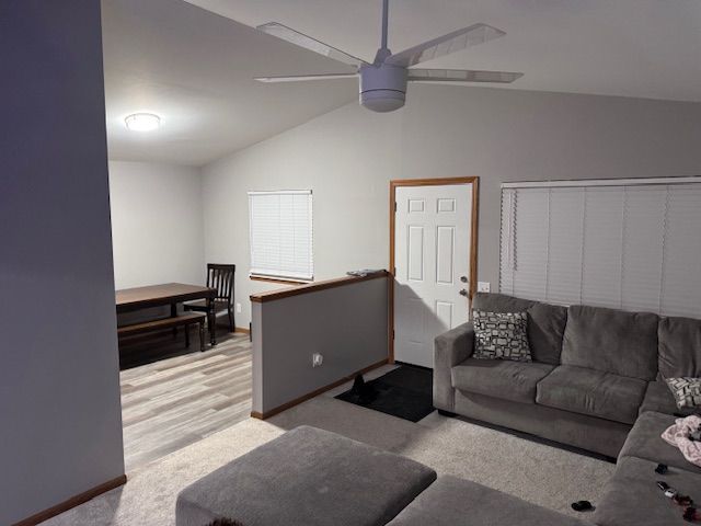 carpeted living room featuring ceiling fan and lofted ceiling