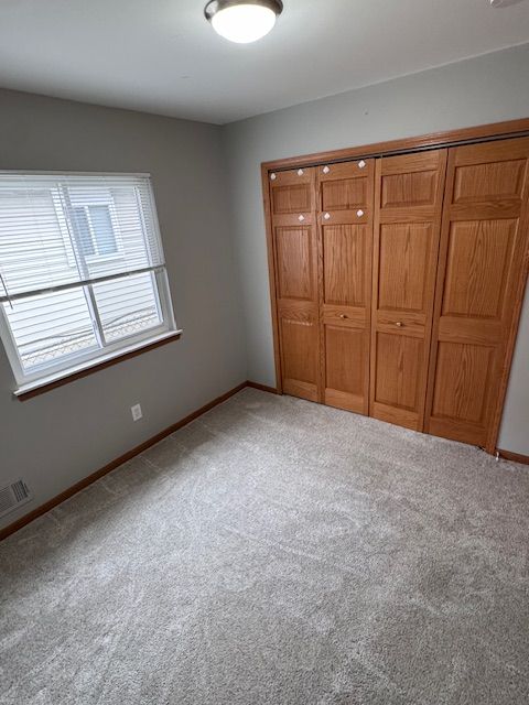 unfurnished bedroom with carpet floors and a closet