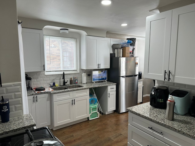 kitchen featuring white cabinetry, stainless steel fridge, sink, and tasteful backsplash