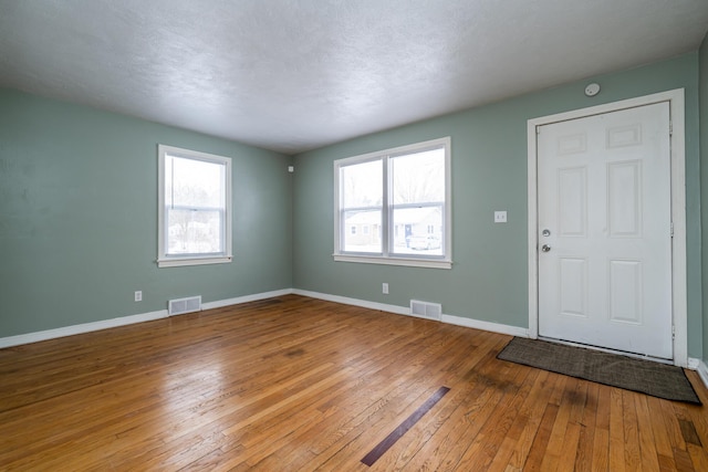 entrance foyer with light hardwood / wood-style floors and a textured ceiling