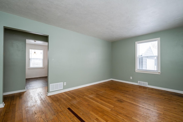 unfurnished room featuring hardwood / wood-style flooring and a textured ceiling