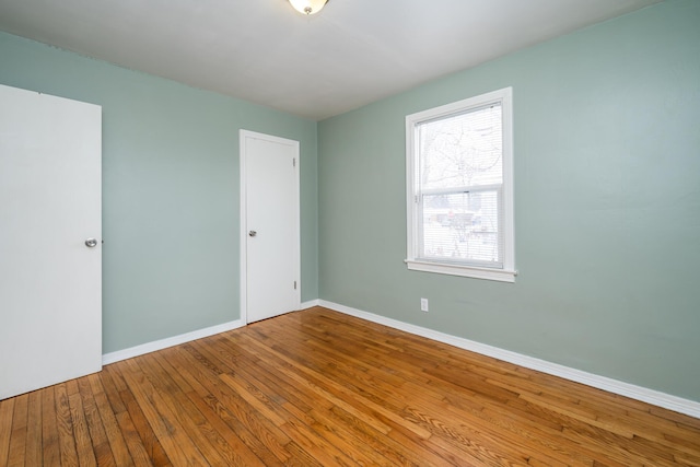 spare room featuring wood-type flooring and plenty of natural light