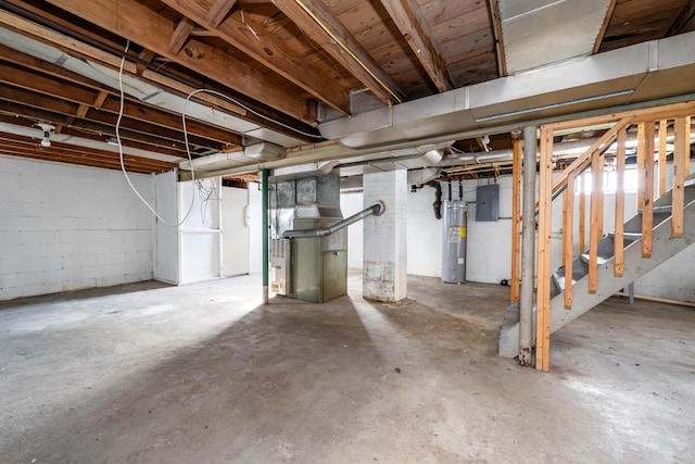 basement with water heater, heating unit, and electric panel