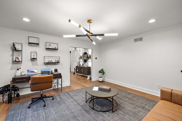 office area with ornamental molding, hardwood / wood-style floors, and a notable chandelier