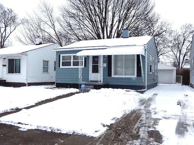 view of front of house with a garage and an outbuilding