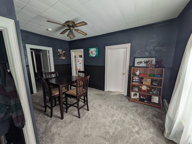 dining area featuring ceiling fan, crown molding, light carpet, and baseboard heating