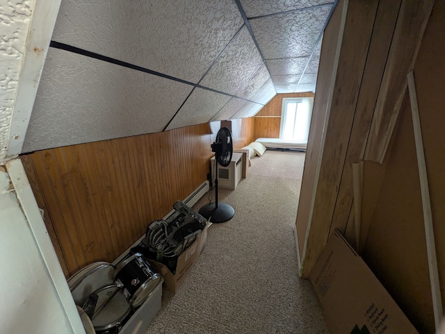 workout area featuring vaulted ceiling, wood walls, and carpet flooring