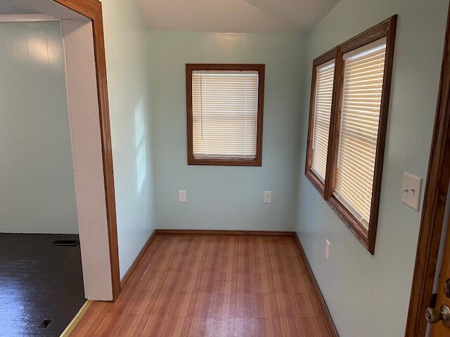 empty room with lofted ceiling and light hardwood / wood-style flooring