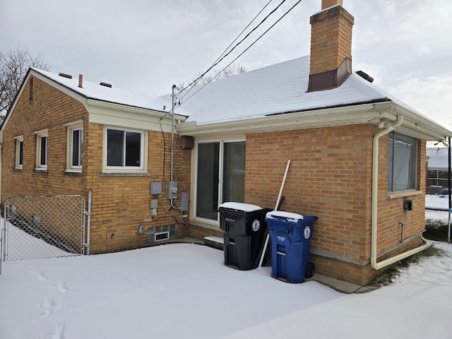 view of snow covered rear of property