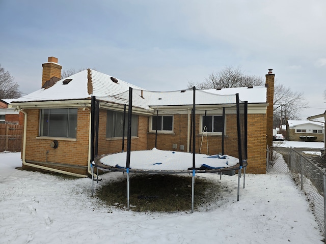 view of snow covered back of property