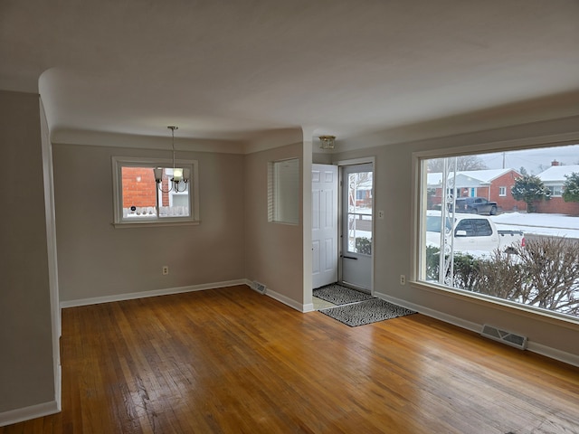 interior space with hardwood / wood-style floors and a notable chandelier