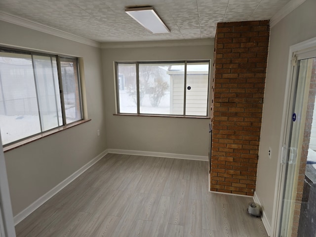 empty room with crown molding and light hardwood / wood-style floors