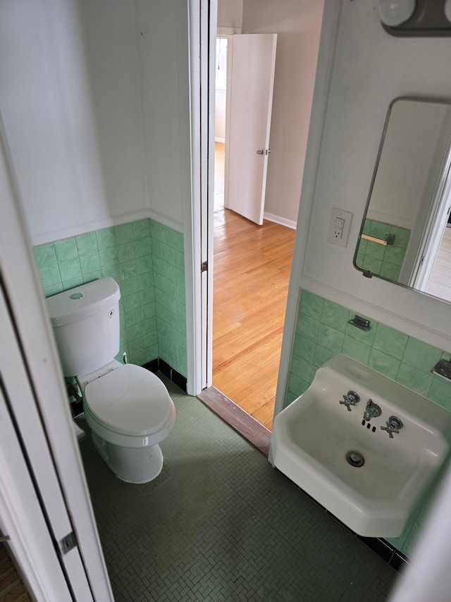 bathroom with tile walls and toilet