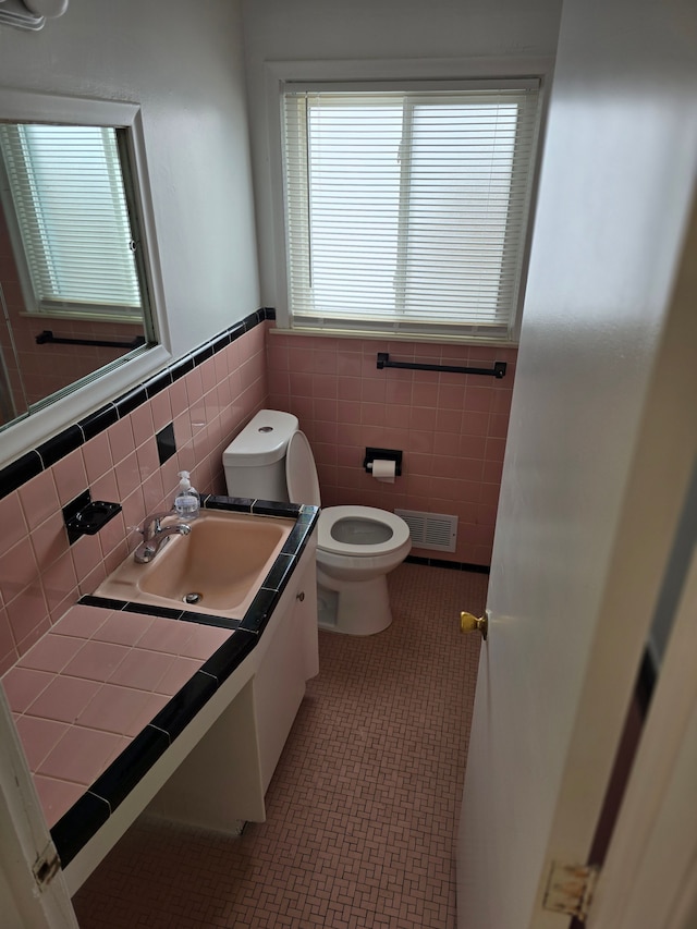 bathroom with tile walls, vanity, and toilet