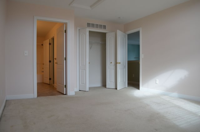 unfurnished bedroom with light colored carpet and a closet