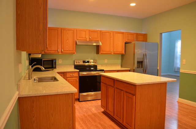 kitchen featuring sink, light wood-type flooring, stainless steel appliances, and a kitchen island